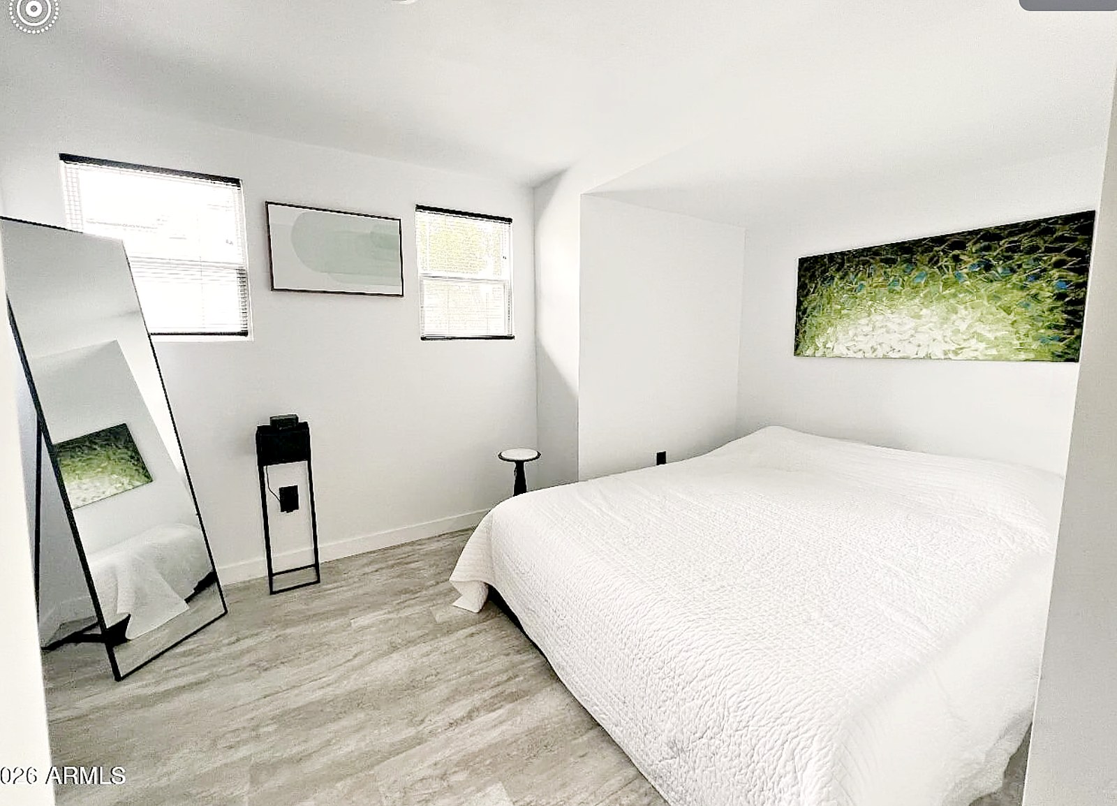 Queen bedroom with white bedding and natural light